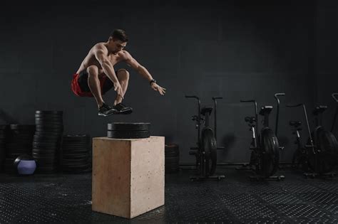 Premium Photo | Young crossfit athlete doing box jump exercise at the gym