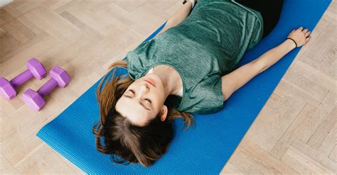 Slim woman lying in Shavasana pose on yoga mat · Free Stock Photo