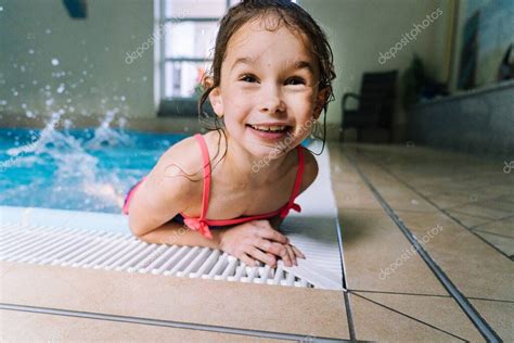 Retrato chica divirtiéndose en piscina cubierta. La chica está ...