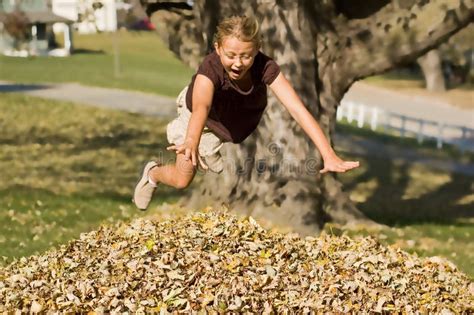 Girl Jumping Into Leaf Pile Stock Image - Image of jumping, leafpile: 11620871