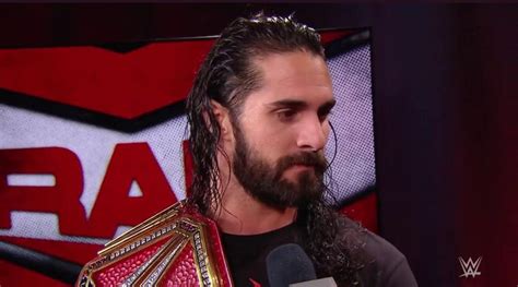 a man with long hair and beard holding a wrestling belt in front of a ...