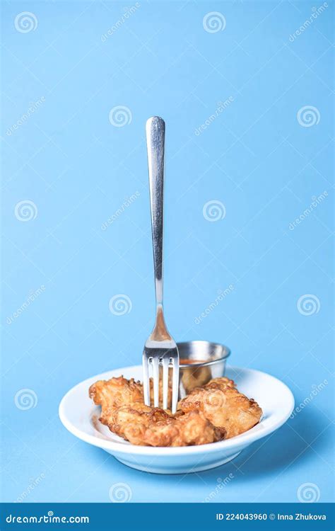 Golden Chicken Nuggets in a White Plate with Sauce. Served Over Light ...