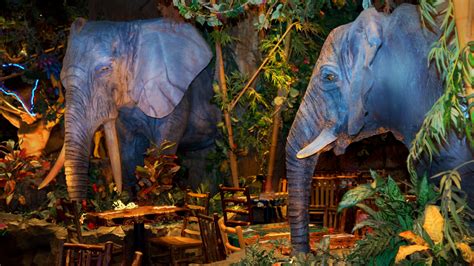 Two animatronic elephants and foliage adjacent to tables