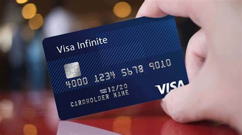 Download A Person Holding Up A Visa Infinite Credit Card | Wallpapers.com