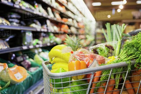 Close up of full shopping cart in grocery store - Stock Photo - Dissolve