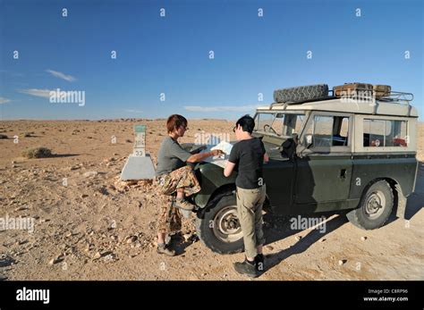 Africa, Tunisia, between Matmata and Kebili. Desert travellers Kerstin and Doris reading the map ...