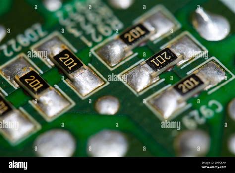 Multiple SMD resistors soldered on a green printed circuit board (PCB ...