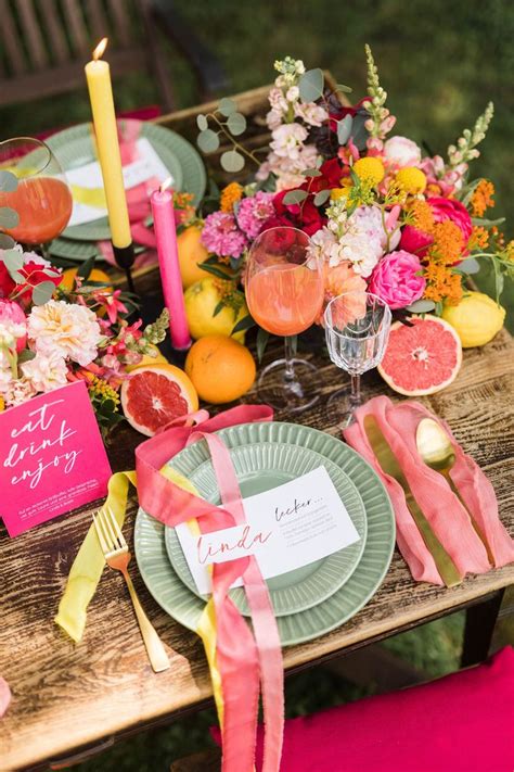 the table is set with plates, napkins and candles for an outdoor ...