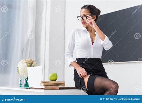 Jeune Professeur Sexy Dans Les Bas Se Reposant Sur Le Bureau Image stock - Image du dispositif ...