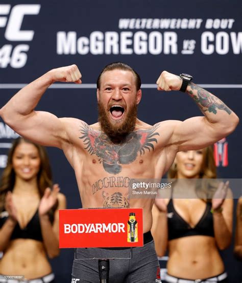 Welterweight fighter Conor McGregor poses on the scale during a... News ...