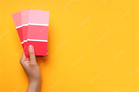 Premium Photo | Female hand holding color palettes on yellow background