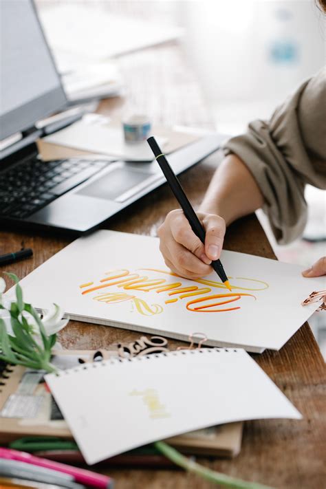 Person Holding Silver Pen Writing on White Paper · Free Stock Photo