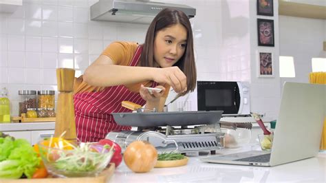 Young Asian woman cooking in kitchen at home. 11273555 Stock Photo at ...