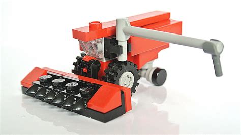 an orange and black toy tractor on a white surface