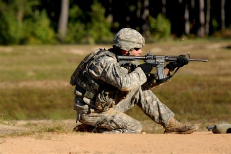 A soldier fires his M4 carbine rifle during a stress shoot range at the ...