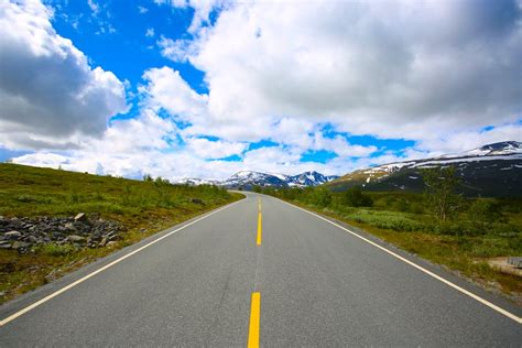 Scenic View of Mountain Road Against Blue Sky · Free Stock Photo