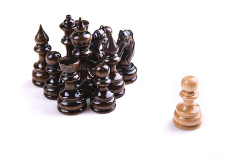 Premium Photo | Single pawn against all black pawns isolated on white background - concept of an ...