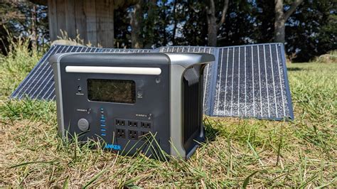 an electronic device sitting in the grass next to a solar panel