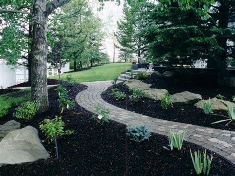 Black Mulch complimenting the Charcoal Cobblestone | Stone landscaping, Backyard landscaping ...