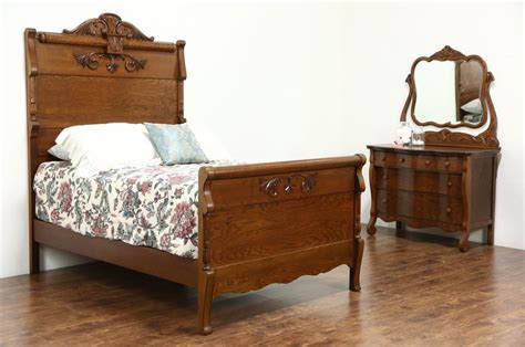 A near-matched oak bedroom set from about 1900 includes a full size bed and chest or dresser ...