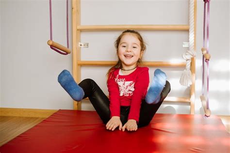 Premium Photo | Happy little girl playing on the soft mate at the monkey bar background