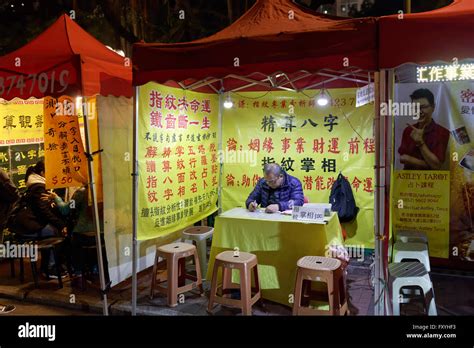 Chinese fortune tellers and palm readers in a lit tent, Temple Street ...