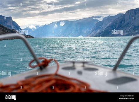 North Pangnirtung fjord with steep cliffs and icebergs floating in the ...