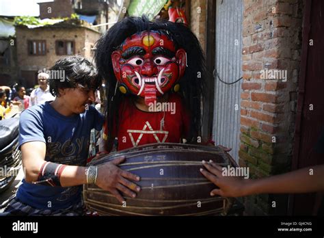 Lalitpur, Nepal. 13th Aug, 2016. A Nepalese person dressed in a Lakhey costume plays traditional ...