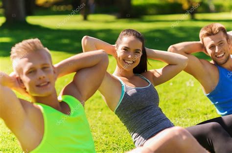 Group of friends or sportsmen exercising outdoors — Stock Photo © Syda_Productions #85005568