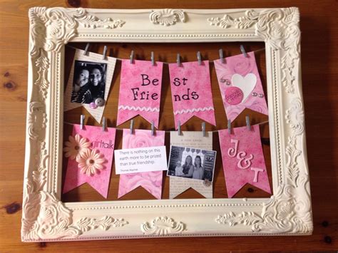 a white frame with pink bunting and pictures on it