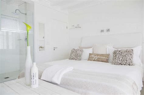 White bedroom with en suite shower in luxury hotel room stock photo