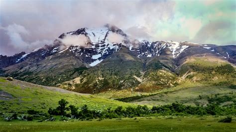 Landscape photography of green fields and snow covered mountain range HD wallpaper | Wallpaper Flare