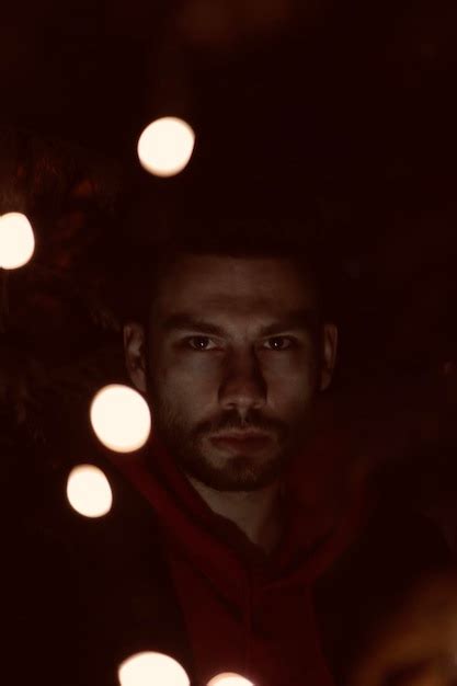 Premium Photo | Portrait of man with illuminated string lights at night