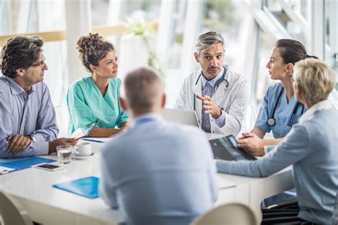 Team of doctors and business people talking on a meeting at doctor’s ...