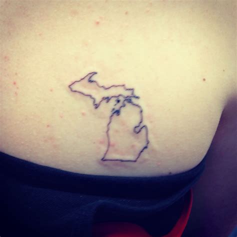 a woman's shoulder with a small outline of the state of michigan on it