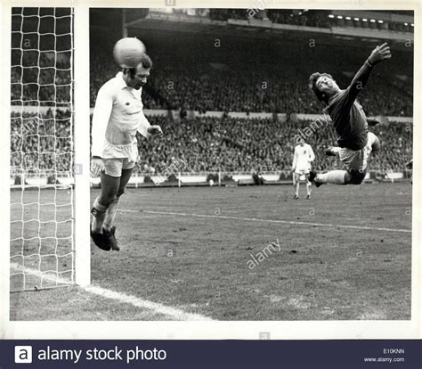 an old black and white photo of two soccer players in mid air during a game