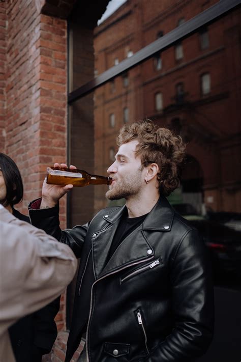 Man in Black Leather Jacket Drinking Beer · Free Stock Photo