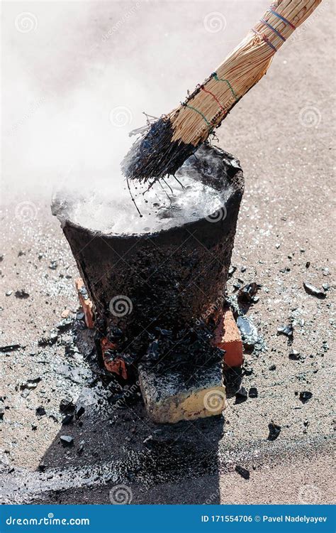 Worker Repairs the Roof with Molten Tar from a Bucket with a Broom ...