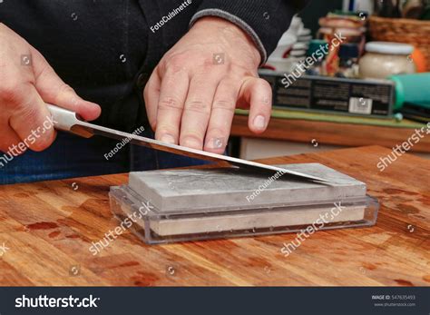 Unrecognizable Man Using Whetstone For Knife Sharpening. Sharpening Knife Blade On Grindstone ...