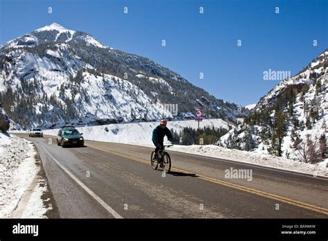 Bicyclist in winter on The Million Dollar Highway western Colorado between Silverton and Ouray M ...