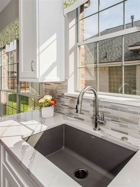 a kitchen sink sitting under a window next to a counter top with ...