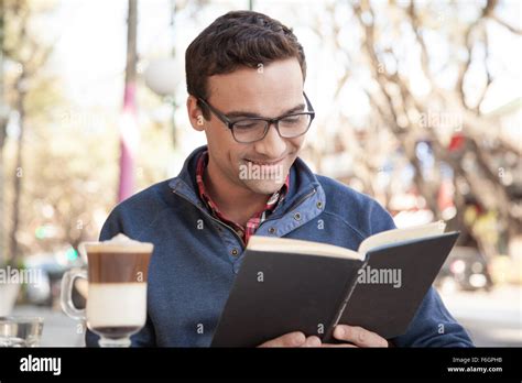 Man reading a book while drinking a coffee Stock Photo - Alamy