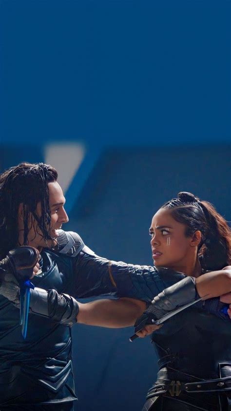 two people standing next to each other in front of a blue background