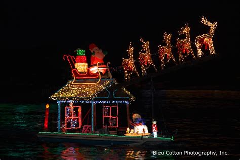 a boat decorated with christmas lights and santas on it's roof in the water