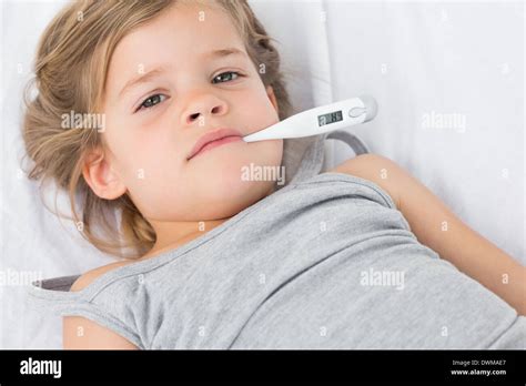 Sick girl with thermometer in mouth Stock Photo - Alamy