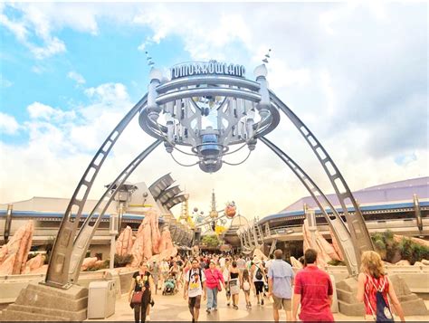 people are walking through the entrance to an amusement park