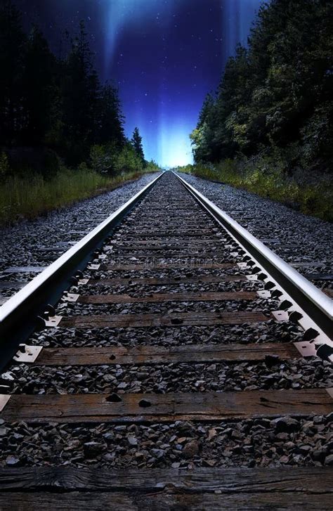 Looking Down Train Tracks at Night with Northern Lights in Sky Stock Image - Image of back ...