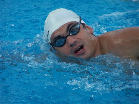 a man swimming in a pool with goggles on