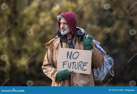 Homeless Beggar Man Standing Outdoors in Park, Holding Bag and Cardboard Sign. Stock Photo ...