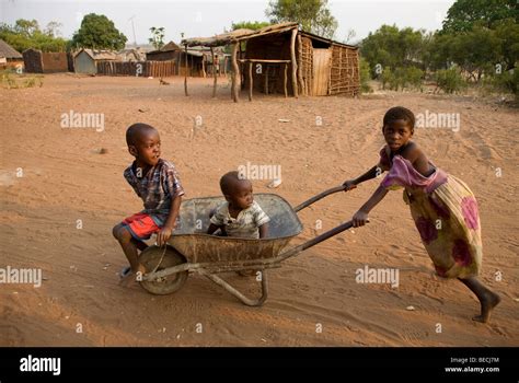 Children playing with a wheel barrow, African village Sambona, Southern Province, Republic of ...